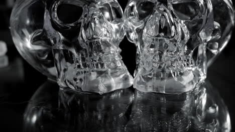 Rotating-Scary-Glass-Skulls-with-Black-Background,-Low-Dolly