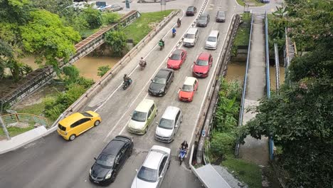 View-from-above,-vehicles-line-up-long-to-cross-the-traffic-light-intersection