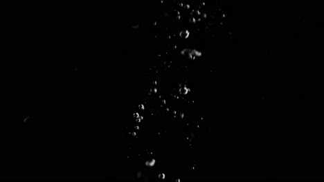Lemon-Slice-Falling-into-Water-Super-Slowmotion,-Black-Background,-lots-of-Air-Bubbles,-4k240fps