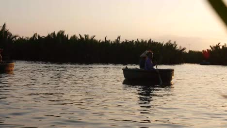 Menschen-Auf-Korbbooten,-Die-Bei-Sonnenuntergang-In-Tam-Coc,-Vietnam,-Auf-Dem-Ruhigen-Wasser-Schwimmen