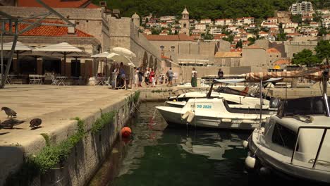 The-harbor-east-of-old-town-Dubrovnik,-Croatia,-and-some-tourists-wandering-by
