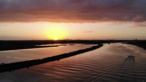Sonnenuntergang-Auf-Einem-Holländischen-Fluss,-Während-Schwalben-Herumfliegen-Und-Ein-Schnellboot-Auf-Dem-Fluss-Fährt