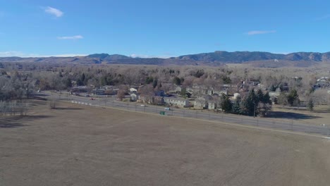 Fort-Collins-Colorado-drone-flight-facing-the-rocky-mountains-on-a-blue-sky-and-hazy-warm-morning-in-December-2020-during-the-pandemic