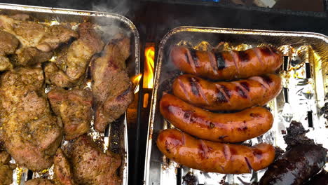 Slices-of-marinated-meat-and-sausages-grilled-on-metal-trays-outside-the-house-during-the-daytime