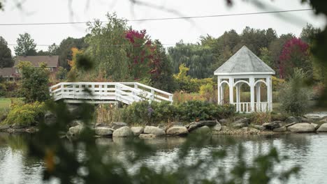 Beautiful-pavilion-on-a-island-in-the-middle-of-a-body-of-water-with-a-white-bridge-spanning-across-to-the-island
