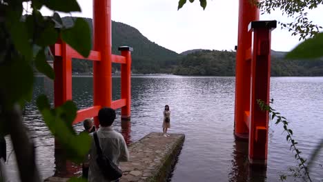 Slow-motion-push-out-between-trees-at-Hakone-Shrine-with-happy-girl-posing