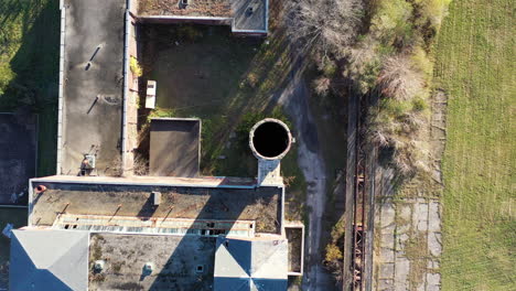 an-aerial,-top-down-view-over-the-opening-of-an-abandoned-smoke-stack