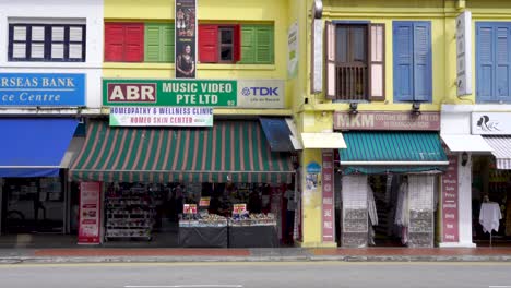 People-waking-along-traditional-shophouses-at-Seragoon-Road,-Little-India