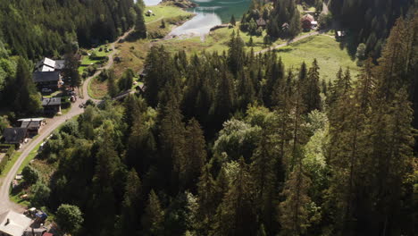 Von-Baumwipfeln-Aus-Mit-Einem-Atemberaubenden-See-Und-Einem-Wunderschönen-Berghang-Im-Hintergrund-Hinunterfliegen