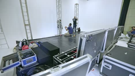 Orbital-tracking-shot-of-a-crew-setting-up-a-stage-in-a-broadcast-studio