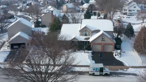 Ein-US-Briefträger-Liefert-Ein-Weihnachtspaket-Mit-Schnee-Bedeckt-Nach-Hause