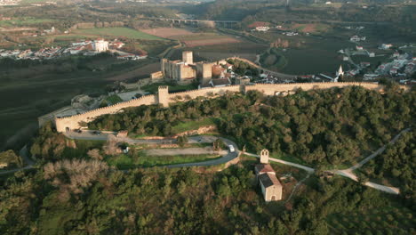 Las-Murallas-De-La-Ciudad-Medieval-Del-Castillo-De-Obidos-En-Portugal-En-Un-Día-Soleado---Toma-Aérea-De-Drones