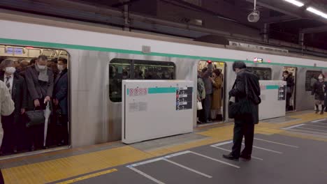 Voller-Tokioter-U-Bahn-Zug,-Zeitlupenschwenk-über-Den-Geschäftigen-Berufsverkehr