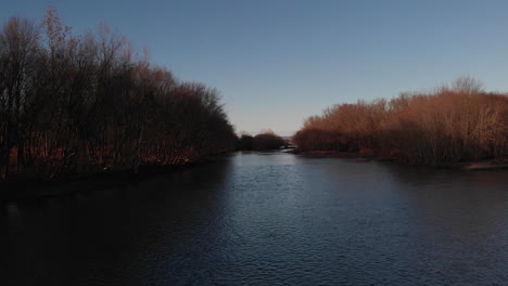 Narrow-channel-along-riverway-on-Susquehanna-river-in-Pennsylvania-in-winter-at-sunset,-Aerial,-Slow-Motion