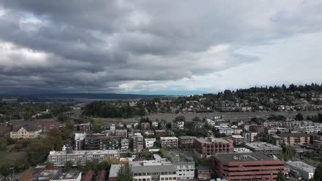 Dunkle-Gewitterwolken-über-Dem-Wohngebiet-Seattle-Und-Lake-Washington-Im-Hintergrund,-Luftrutsche