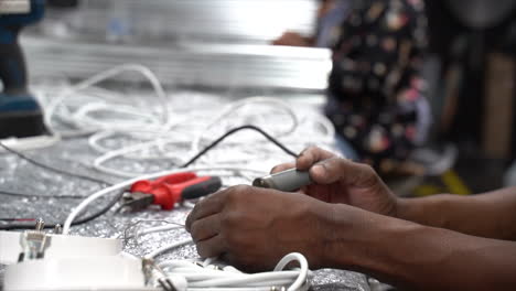 Skilled-hands-soldering-cables-at-a-workbench-preparing-them-for-further-soldering