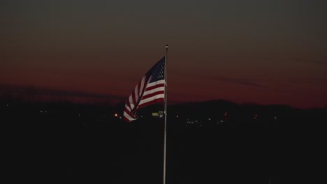 United-States-flag-flying-with-a-sun-set-background
