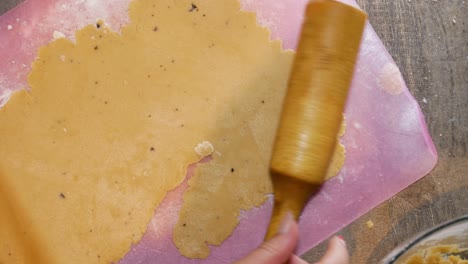 Female-hands-are-using-a-wooden-rolling-pin-for-gingerbread-cookie-dough