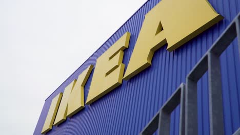Primer-Plano-Del-Logotipo-De-Ikea-Con-Letras-Amarillas-En-La-Fachada-Azul-En-Cámara-Lenta