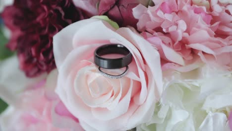 Macro-shot-of-wedding-rings-posed-on-the-rose-pedal-leaves-for-a-designer-photo-shoot