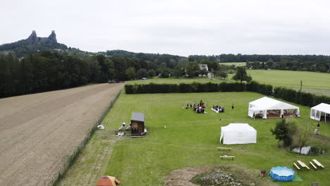 Outdoor-wedding-ceremony-in-a-grassy-field-below-a-castle-ruin,Czechia