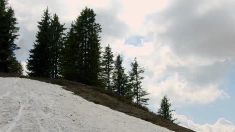 Mountain-biker-rides-down-steep-snow-patch-fast