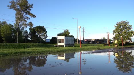 A-man-runs-on-a-flooded-service-road-on-a-sunny-afternoon