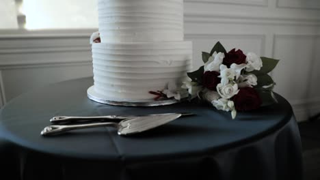 Beautiful-tiered-wedding-cake-with-server-set-and-flower-bouquet-at-a-reception-at-Orchard-View-Wedding-Event-Centre-in-Ottawa,-Canada