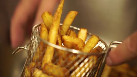 SLOWMO---Close-Up---Putting-perfectly-cooked-crispy-french-fries-into-a-metal-basket