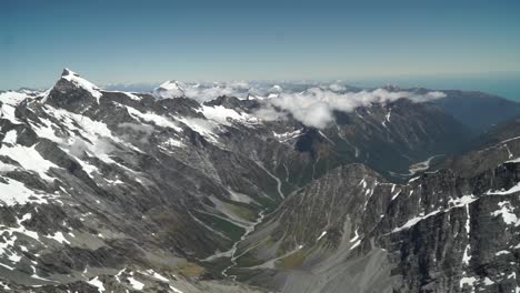 Aerial-shot-from-plane-scenic-flight-over-west-coast-Franz-Josef-Glacier-Aoraki-Mount-Cook,-National-Park-with-clouds,-snowcapped-rocky-mountains-and-ocean-in-background