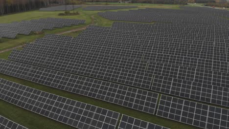 drone-shot-of-reavaling-huge-solar-park-near-the-highway-and-forest-on-the-other-side