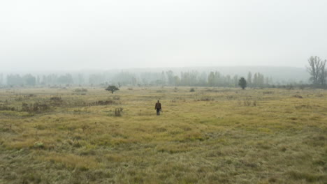 Documentarist-with-a-camera-walking-in-a-foggy-moorland,autumn,Czechia