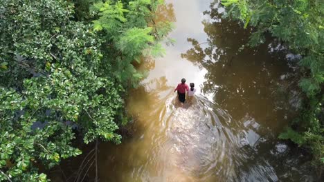 Einsame-Familie-Kämpft-Sich-Durch-Eine-überflutete-Straße,-Die-Durch-Starke-Regenfälle-In-Kambodscha-Verursacht-Wurde