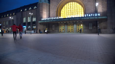 Pedestrians-crossing-the-square-in-front-of-the-Central-Railway-Station-in-Helsinki,-Finland