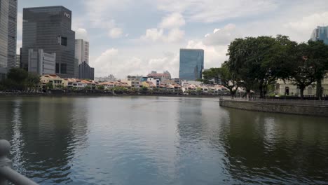 Caminando-Cerca-Del-Río-Singapur-Con-Edificios-Urbanos-En-Segundo-Plano-En-Singapur