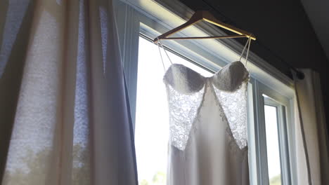 Wunderschönes-Weißes-Hochzeitskleid,-Das-An-Einem-Fenster-In-Einem-Alten-Holzhaus-Hängt