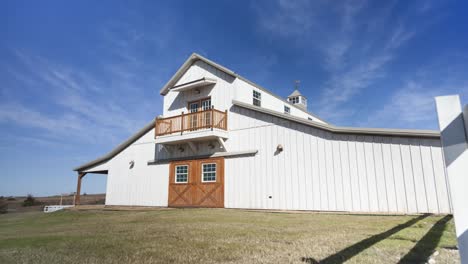Timelaspe-of-a-rustic-white-barn-in-the-country-side-as-people-walk-around
