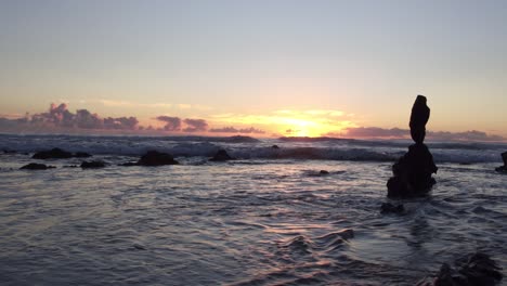 Atemberaubender-Blick-Auf-Den-Sonnenuntergang-Bei-Ebbe-Am-Laguna-Beach,-Während-Die-Sonne-Zwischen-Den-Felsen-Aufgeht-Und-Sich-Im-Wasser-Spiegelt