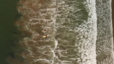 Aerial-shot-of-two-female-surfers-paddling-out-to-surf-in-Southern-California