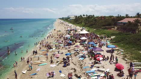 Beach-paddle-out-crowd-flyover-with-crystal-clear-water-in-South-Florida
