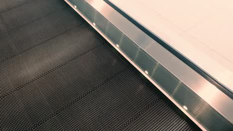First-person-view-point-of-view-of-riding-travelator-at-a-train-station-whilst-looking-at-the-travelator