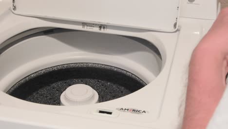 Person-is-placing-items-in-the-washer