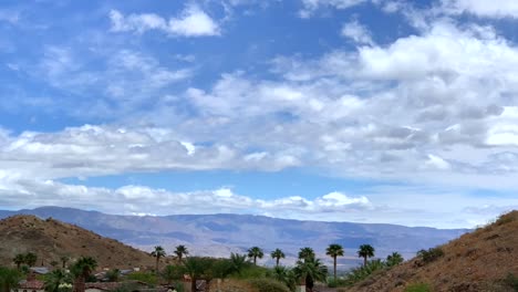 4k-Time-lapse-of-desert-mountain-with-clouds-and-palm-trees-with-blue-skies