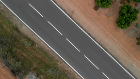 Aerial-view-of-a-spinning-road-with-a-passing-car