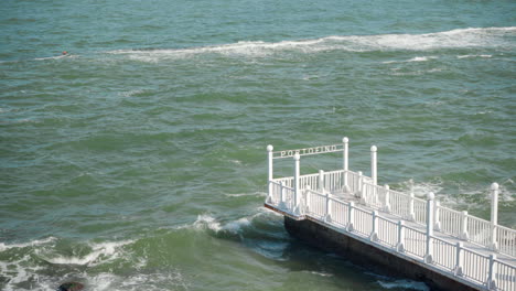 Waves-hitting-empty-white-pier