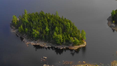 Aerial-footage-of-remote-lake-in-northern-Maine-Panning-down-towards-wooded-island-near-shore