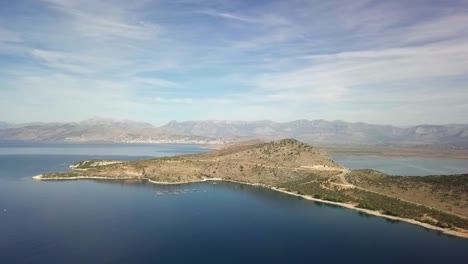 Drone-Vuela-Con-Vistas-A-Ksamil-Y-La-Riviera-Albanesa-En-Un-Cielo-Azul-Perfecto-Día-De-Verano-Y-Las-Montañas-En-El-Fondo