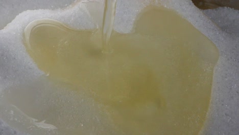 Close-up-of-dropping-a-white-and-yellow-egg-yolk-on-white-sugar-while-baking-in-slow-motion