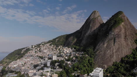 Aerial-pan-showing-the-Two-Brothers-mountain-peaks-in-Rio-de-Janeiro-with-the-favela-of-Vidigal-on-its-steep-descent