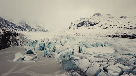 Lengua-Glaciar-En-Islandia-Filmada-Por-Drones-Con-Diferentes-Movimientos-Cinematográficos,-Mostrando-Un-Concepto-Turbio-Y-Dramático-En-Condiciones-Invernales